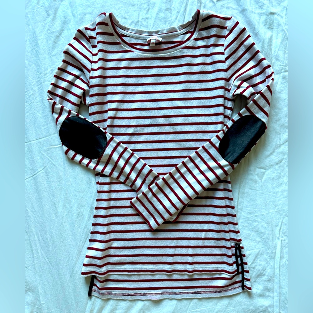 White with red stripes shirt and black elbow pads. Size small